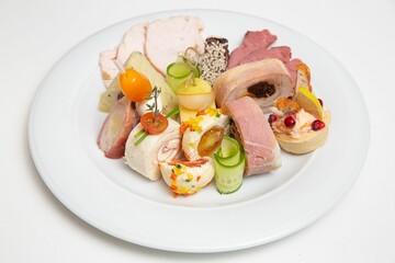 Closeup of a plate with different types of cheese and ham.