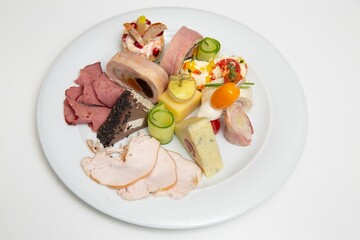 Closeup of a plate with different types of cheese and ham.