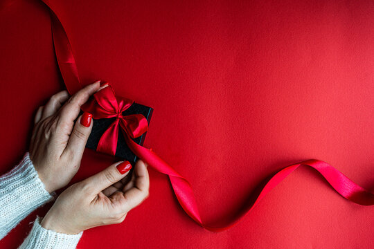 Woman holds the black box on red background