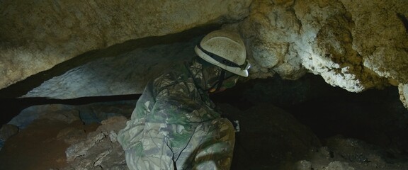 Pov view on deep extreme discovery journey to an old landmark destination. First person shows tourists walking ahead in cave during an excursion, enjoying adventure, natural landscape, ancient walls
