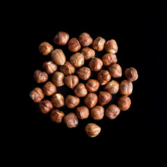 Fresh raw hazelnuts macro view, isolated on black background. Top view.