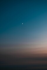 Vertical shot of a sky with the moon at sunset