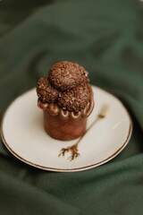 Vertical shot of a a fresh chocolate muffin on a ceramic plate on the table