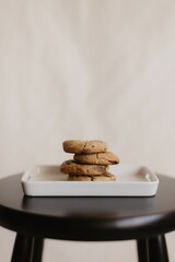 Vertical shot of freshly-baked chocolate cookies on a ceramic tray on the table