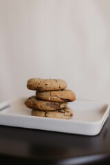 Vertical shot of freshly-baked chocolate cookies on a ceramic tray on the table