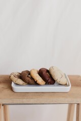 Vertical shot of freshly-baked chocolate cookies on a ceramic tray on the table