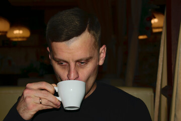 a man drinks coffee in a cafe. portrait. insomnia