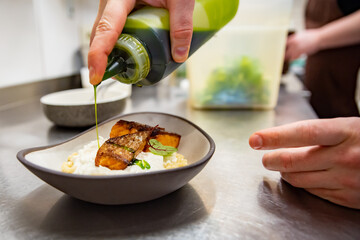 chef hand cooking grilled salmon fish fillet with creamy ptitim