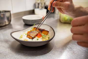chef hand cooking grilled salmon fish fillet with creamy ptitim