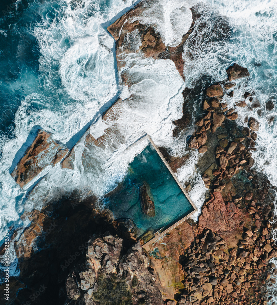 Wall mural aerial view early morning light with ocean waves flowing over rocks around north curl curl ocean roc