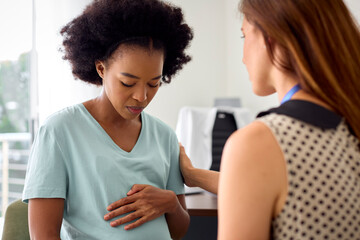 Unhappy Pregnant Woman With Depression At Appointment With Female Doctor Or GP In Office