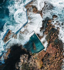 Aerial view early morning light with ocean waves flowing over rocks around North Curl Curl ocean...