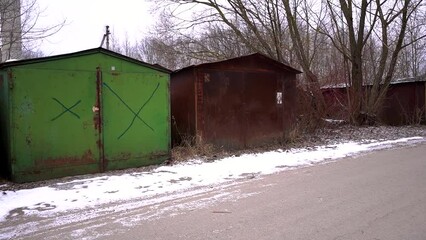 Footage of a colorful Row of garages with snowy ground in the street