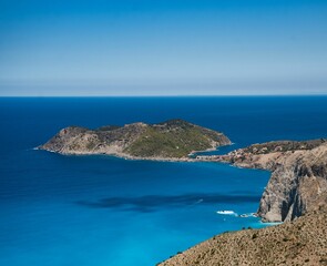 Fototapeta na wymiar a small island sits near the water in a blue sea