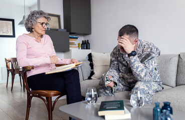 Veteran soldier having therapy meeting with senior female psychologist.