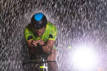 A triathlete braving the rain as he cycles through the night, preparing himself for the upcoming...