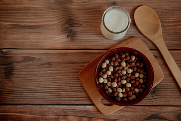 Corn balls for breakfast with milk on a wooden background