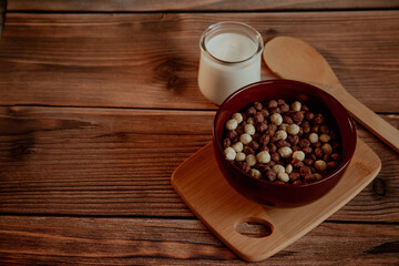 Corn balls for breakfast with milk on a wooden background