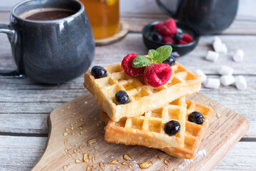 
Belgian waffles with berries. Morning. On a wooden background
