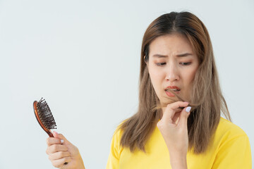 Asian woman very sad and upset looking at damaged hair, hair loss, hair thinning problem, vitamin...