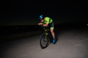 A triathlete rides his bike in the darkness of night, pushing himself to prepare for a marathon....