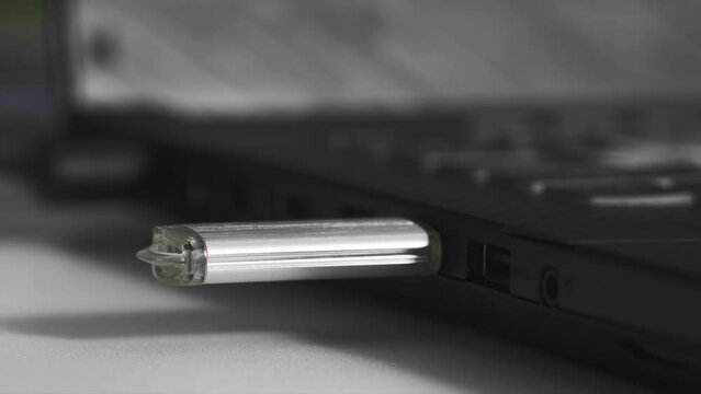 data transfer, flash drive is plugged into USB connector on computer, light is flashing red indicating connection, close-up