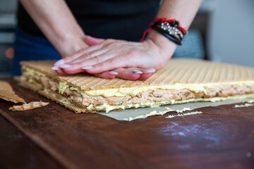 Housewife in the process of preparing delicious wafer biscuit in the  kitchen - pressing with hands
