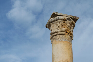 column fragment with capital isolated on a background sky with clouds