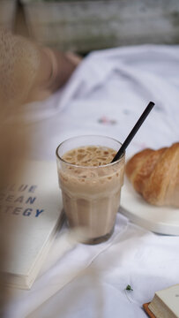coffee milk on picnic blanket with butter croissant on plate  on side, aesthetic image