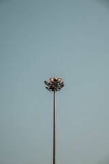 A metal lamp post with lights against a vivid blue sky with a cloudless horizon