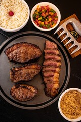 Freshly cooked steak served with a side of fluffy white rice and a salad, ready to be enjoyed