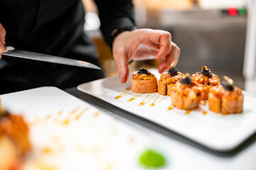 professional chef's hands making sushi and rolls in a restaurant kitchen