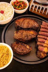 Delicious looking meal of grilled steak, a bowl of cooked rice, and several vegetables
