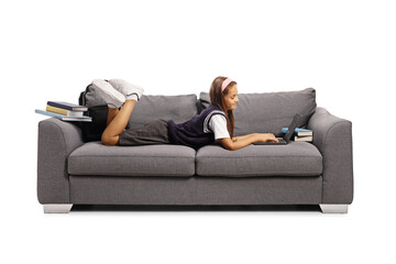 Schoolgirl laying on a sofa and using a laptop computer