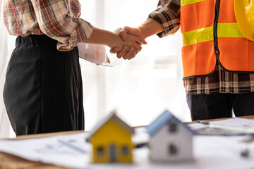 successful team engineers and business partner shaking hand, engineer and architecture shaking hand after finish an agreement, professional engineer plan to build a house