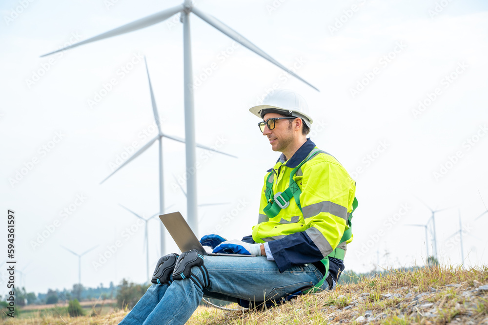 Poster engineer inspecting a wind turbine,wind turbines are an alternative electricity source to be sustain