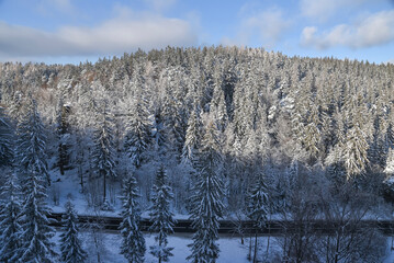 .Asphalt road in the mountains in winter in the forest, top view. Winter mountain landscape.