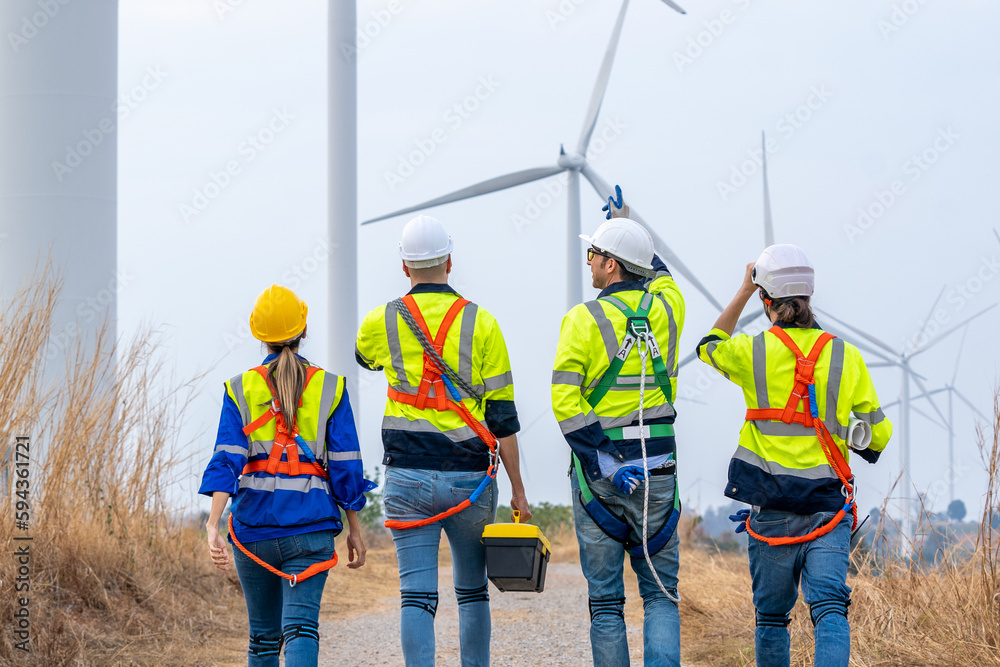 Poster engineer with technician are inspection work in wind turbine farms rotation to generate electricity 