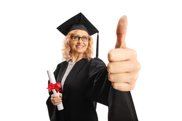 Woman in a black graduation gown holding a certificate and gesturing thumbs up