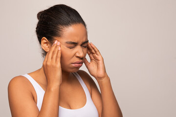 Closeup of young african american woman suffering from headache