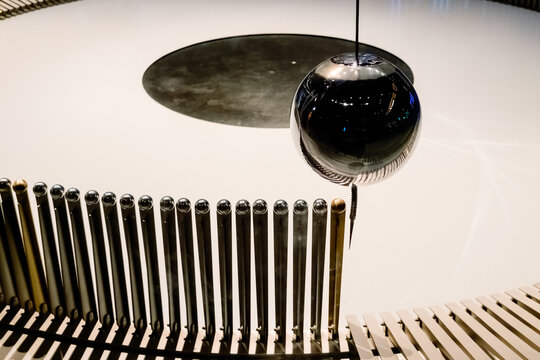 Swinging ball of the Eddy pendulum in a science demonstration. - Powered by Adobe