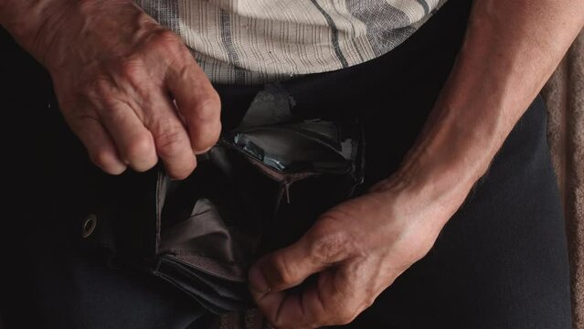 in the hands of an old man an empty old tattered wallet, impoverishment in old age, bankruptcies, unemployment, financial losses, recession and inflation