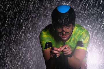 A triathlete braving the rain as he cycles through the night, preparing himself for the upcoming...