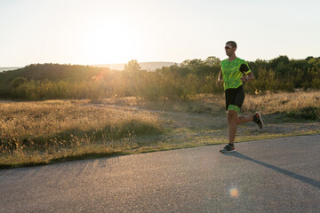 Triathlete in professional gear running early in the morning, preparing for a marathon, dedication to sport and readiness to take on the challenges of a marathon. 