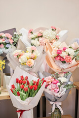 Flower shop concept. Different varieties fresh spring flowers in refrigerator room for flowers. Bouquets on shelf, florist business