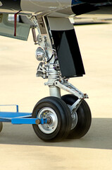 details of airplane landing gear parked at airport - obrazy, fototapety, plakaty
