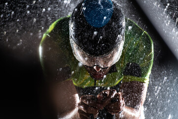 A triathlete braving the rain as he cycles through the night, preparing himself for the upcoming...