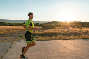 Triathlete in professional gear running early in the morning, preparing for a marathon, dedication...