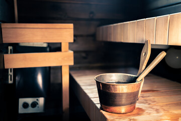 Sauna, spa wellness steam room in Finland. Wooden summer cabin interior. Electric stove in city home or hotel. Ladle and water bucket. Health bath. Modern heater. Traditional Finnish therapy.