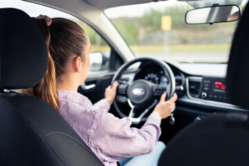 Woman driving car. Young driver. Testing vehicle in dealership or student training in school to get...